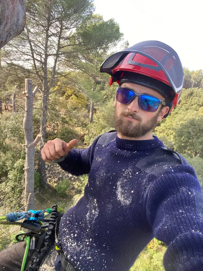 Enzo Cotta, élagueur, casque et lunettes de protection, dans un chêne